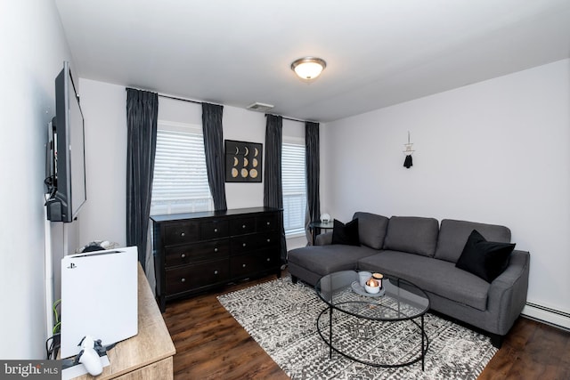 living room featuring dark wood-type flooring and a baseboard heating unit