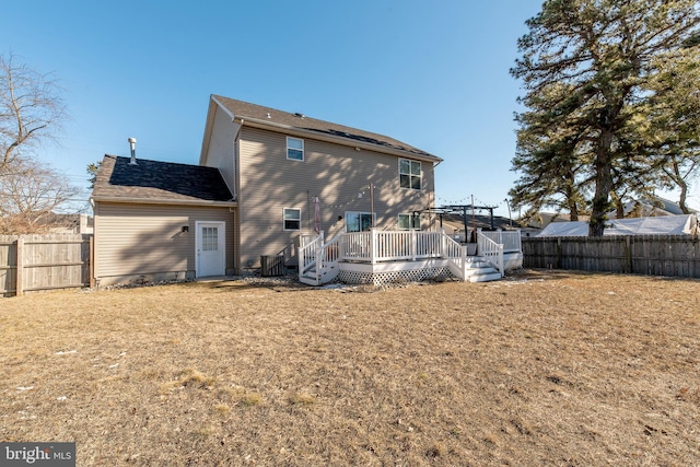 back of house featuring a lawn and a deck