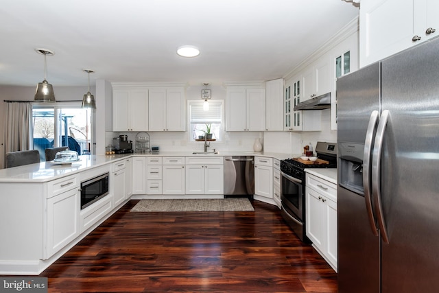 kitchen featuring decorative light fixtures, white cabinetry, sink, kitchen peninsula, and stainless steel appliances