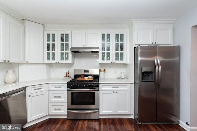 kitchen with appliances with stainless steel finishes, white cabinets, and backsplash