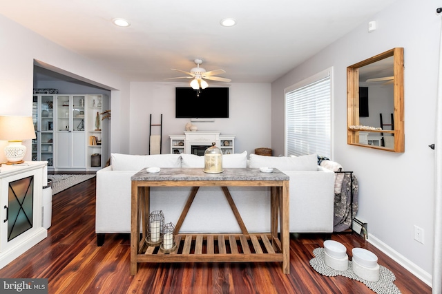 living room featuring ceiling fan, a baseboard radiator, and dark hardwood / wood-style floors