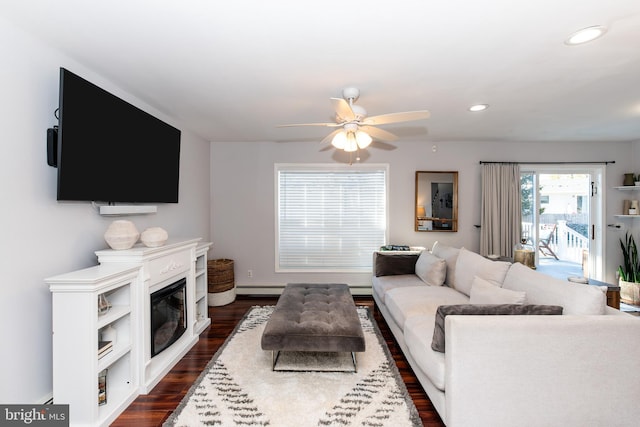 living room with dark hardwood / wood-style flooring, a baseboard radiator, and ceiling fan