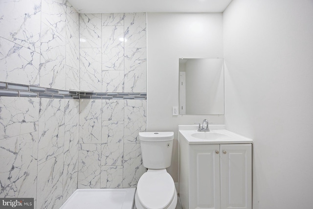 bathroom featuring vanity, walk in shower, and toilet