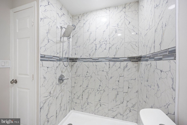 bathroom featuring toilet and a tile shower