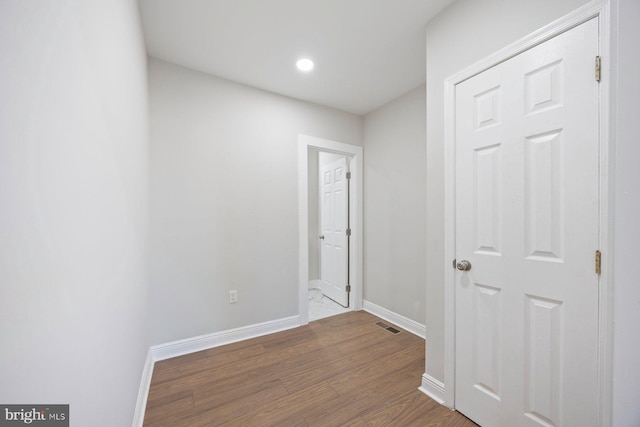 hallway with hardwood / wood-style flooring