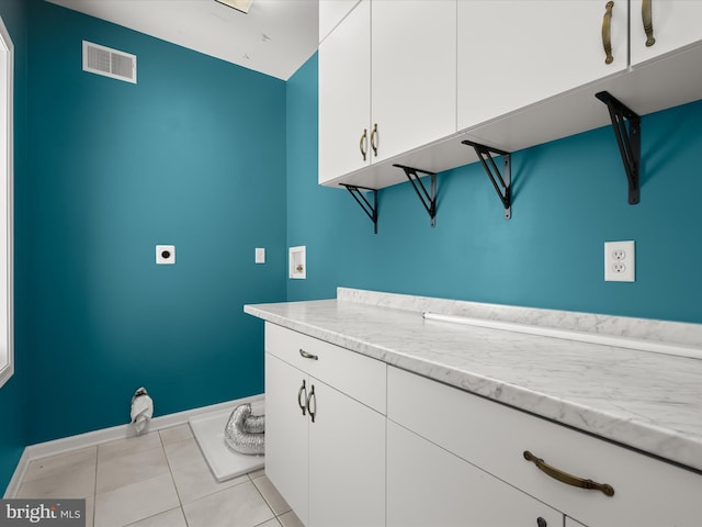 washroom featuring hookup for a washing machine, electric dryer hookup, light tile patterned floors, and cabinets