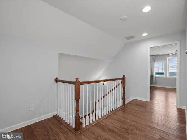 hallway featuring wood-type flooring and vaulted ceiling