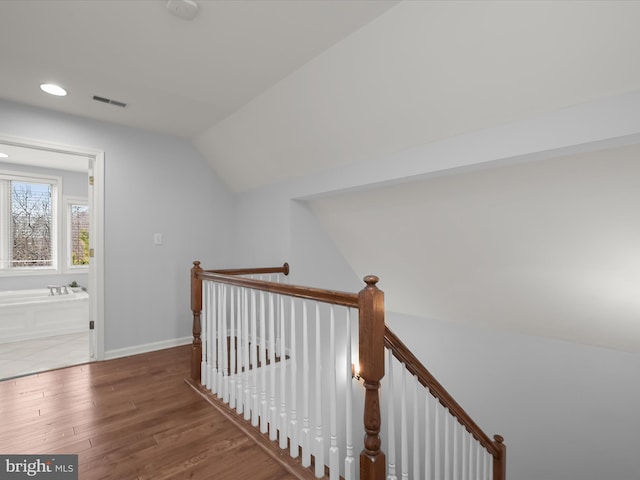 staircase featuring hardwood / wood-style flooring and lofted ceiling