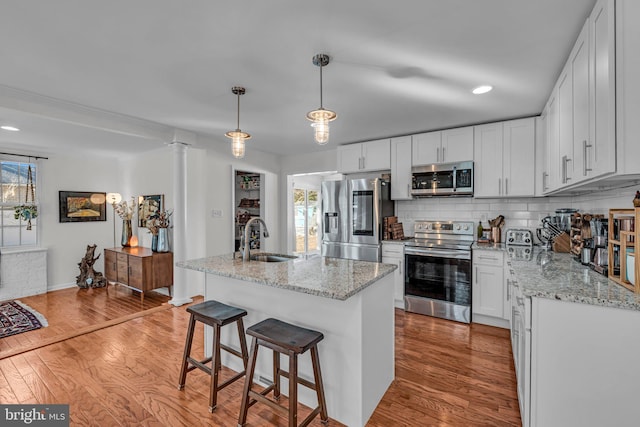 kitchen with white cabinetry, pendant lighting, an island with sink, and appliances with stainless steel finishes