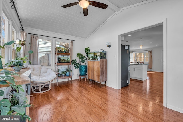 living area featuring vaulted ceiling, sink, ceiling fan, and light wood-type flooring