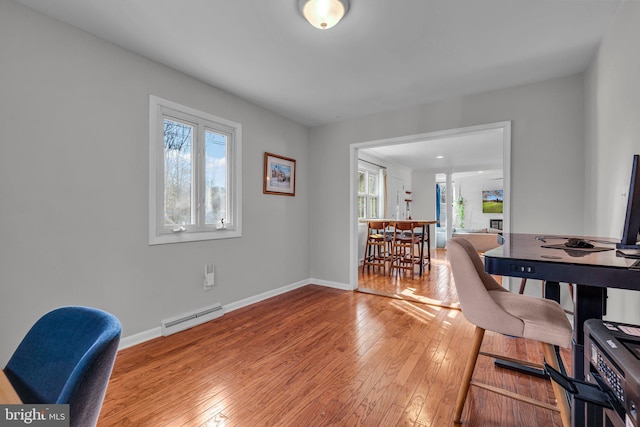 dining area with a wealth of natural light, light hardwood / wood-style floors, and a baseboard radiator