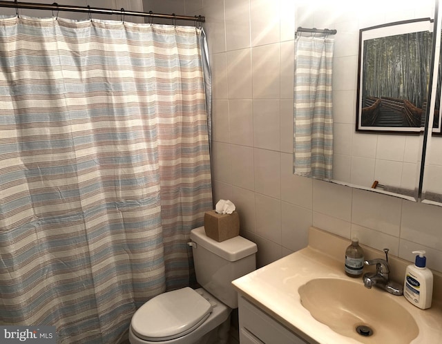 bathroom with tasteful backsplash, vanity, toilet, and tile walls