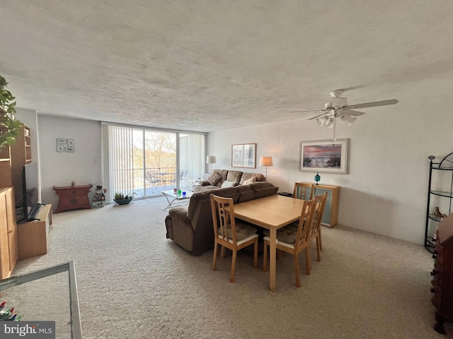 dining room with ceiling fan, carpet flooring, and a textured ceiling