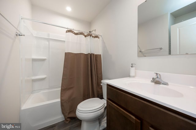 full bathroom with hardwood / wood-style flooring, vanity, shower / tub combo, and toilet