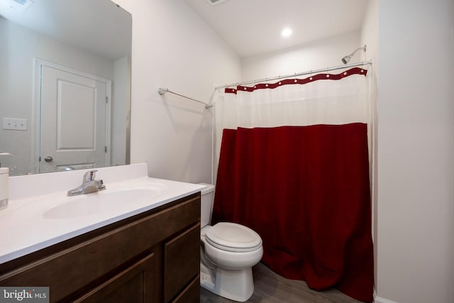 bathroom featuring vanity, toilet, and walk in shower