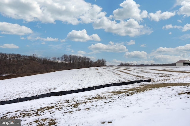 yard covered in snow featuring a rural view