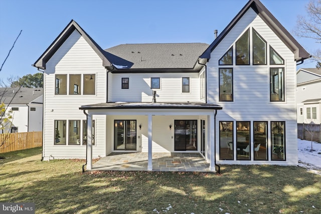 rear view of house featuring a patio and a yard