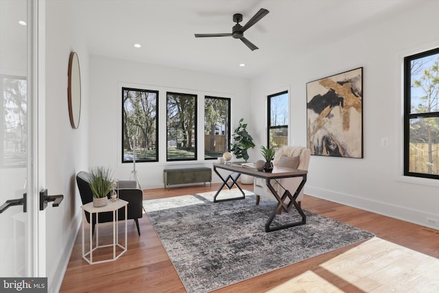 home office featuring light hardwood / wood-style flooring and ceiling fan