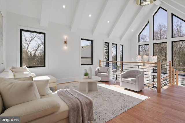 living room featuring beamed ceiling, high vaulted ceiling, and hardwood / wood-style floors