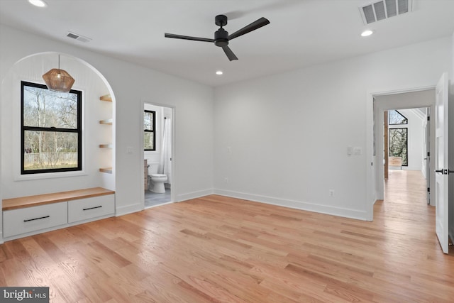 unfurnished bedroom featuring ensuite bath, light hardwood / wood-style floors, and ceiling fan