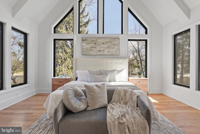 bedroom featuring high vaulted ceiling and light wood-type flooring