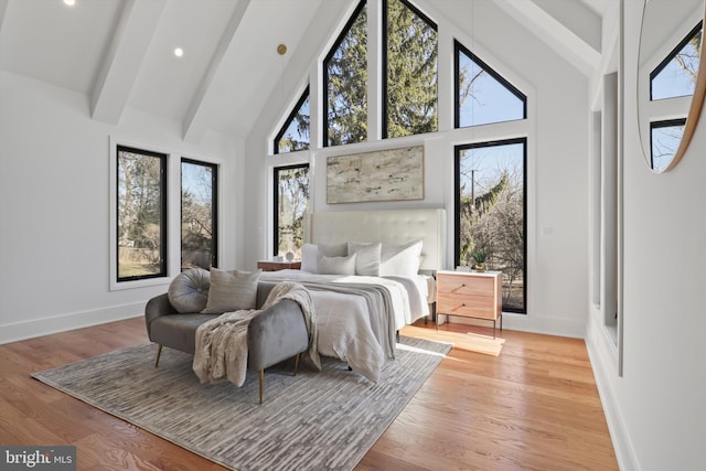 bedroom featuring high vaulted ceiling, light hardwood / wood-style floors, and beamed ceiling