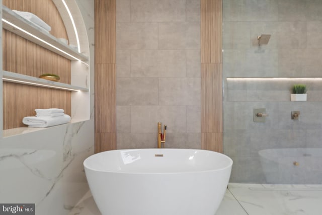 bathroom featuring tile walls and a bath