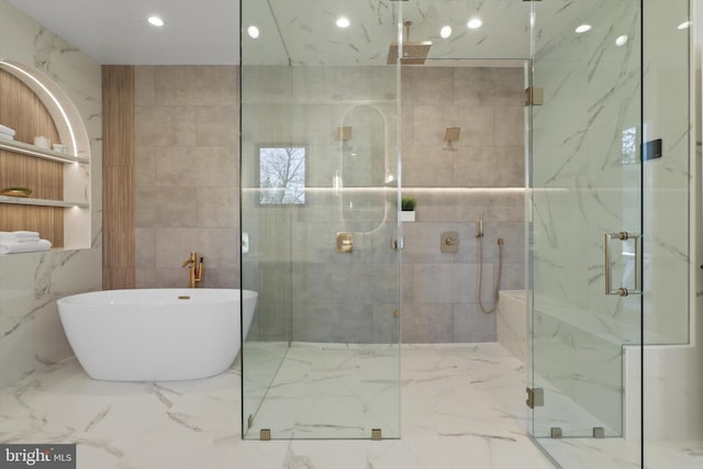 bathroom with shower with separate bathtub and tile walls