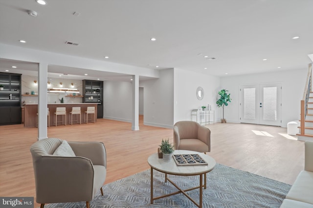 living room featuring french doors and light wood-type flooring