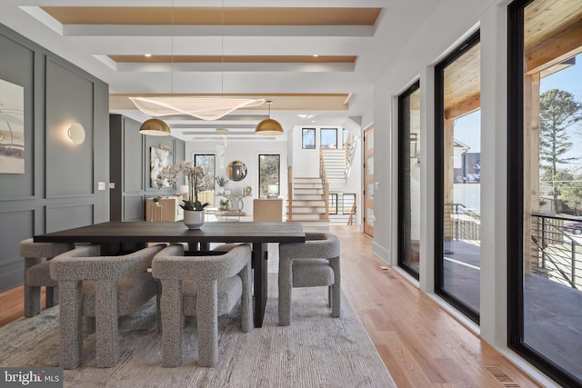 dining area featuring light wood-type flooring and a tray ceiling