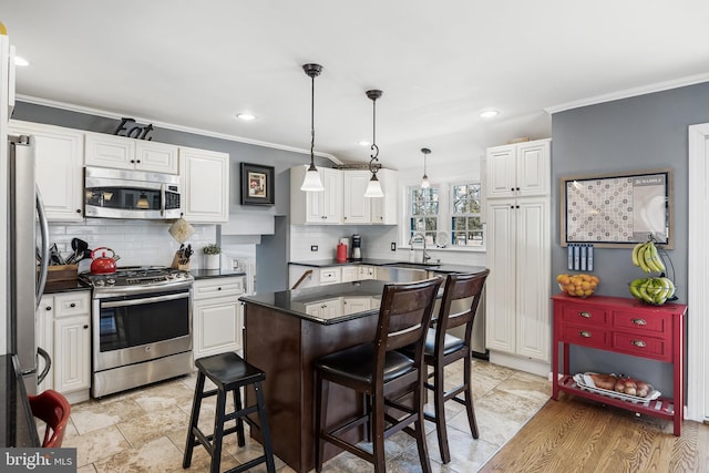 kitchen with white cabinetry, stainless steel appliances, a kitchen island, and a breakfast bar area