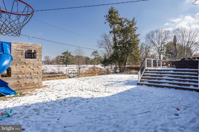 yard layered in snow featuring a playground