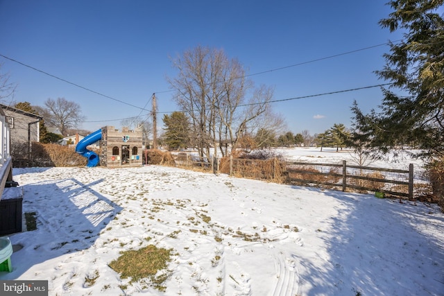 yard layered in snow with a playground