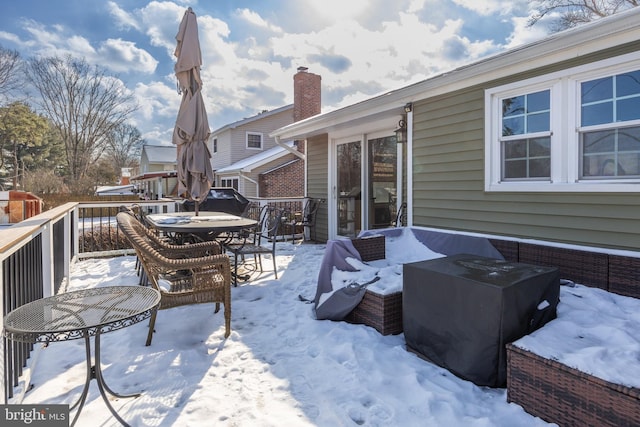 snow covered patio featuring a deck