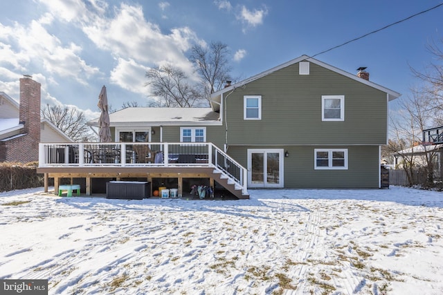 snow covered back of property featuring a wooden deck