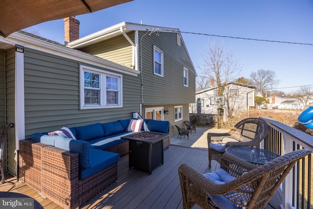 deck featuring an outdoor living space with a fire pit