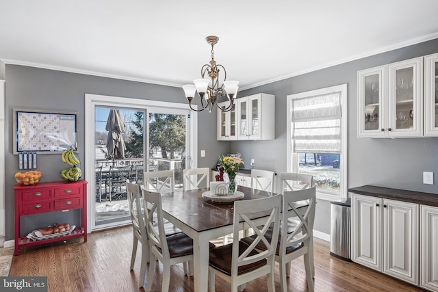 dining room featuring crown molding, plenty of natural light, dark wood-type flooring, and a chandelier