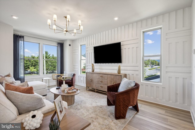 living room with a chandelier and light wood-type flooring