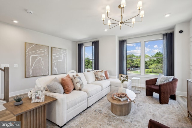 living room featuring a healthy amount of sunlight, light hardwood / wood-style floors, and a notable chandelier