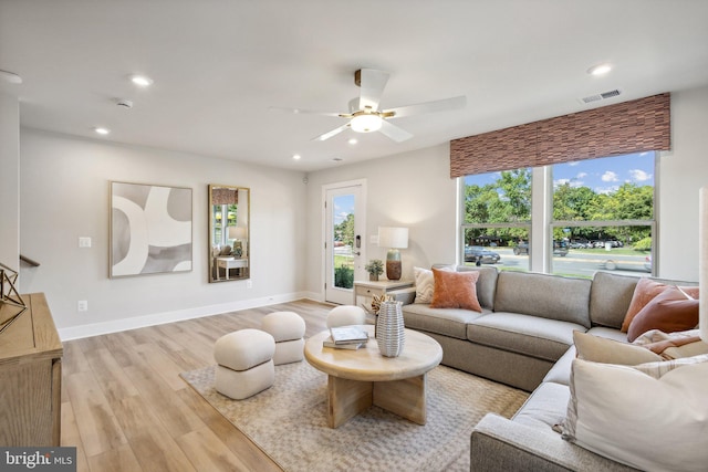 living room featuring ceiling fan and light hardwood / wood-style floors