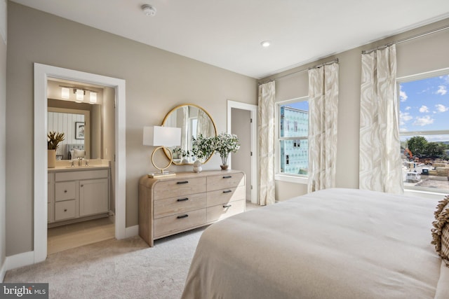 carpeted bedroom with sink and ensuite bath