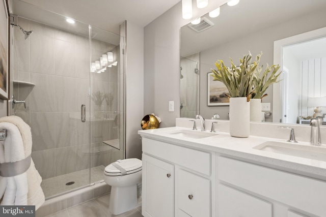 bathroom with tile patterned floors, vanity, toilet, and a shower with shower door