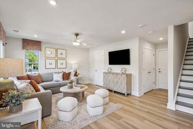 living room featuring ceiling fan and light hardwood / wood-style flooring