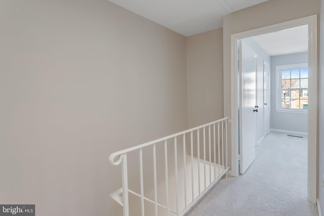 hall featuring light colored carpet