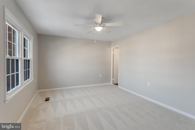 empty room featuring light colored carpet and ceiling fan