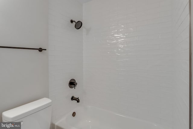 bathroom featuring toilet and tiled shower / bath