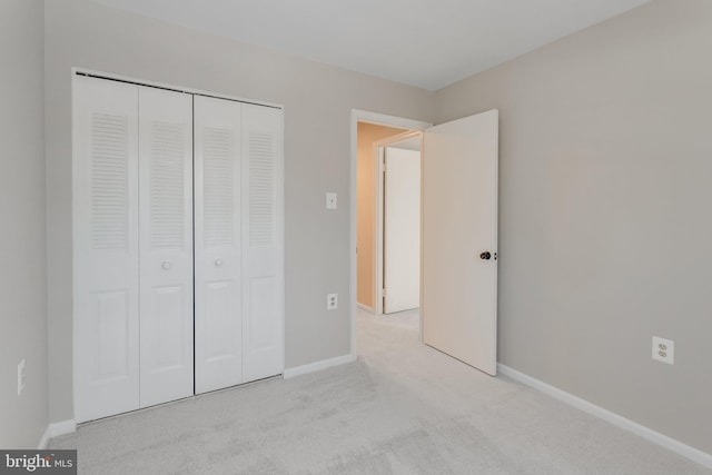 unfurnished bedroom with a closet and light carpet