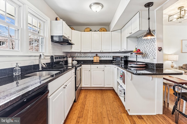 kitchen featuring under cabinet range hood, dishwasher, a breakfast bar area, stainless steel electric range oven, and a sink