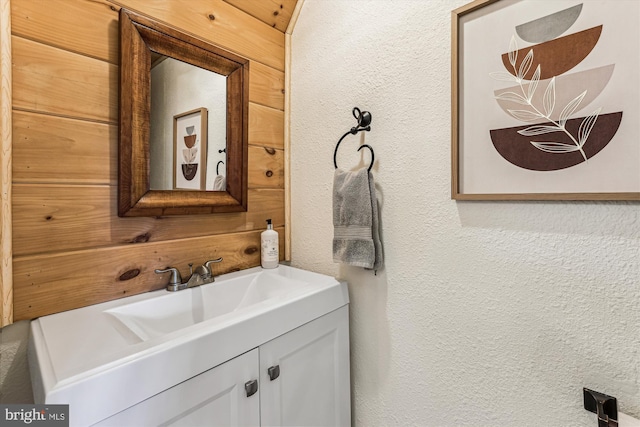 bathroom featuring vanity and a textured wall