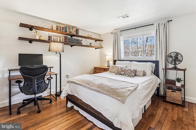 bedroom featuring visible vents, baseboards, and hardwood / wood-style floors